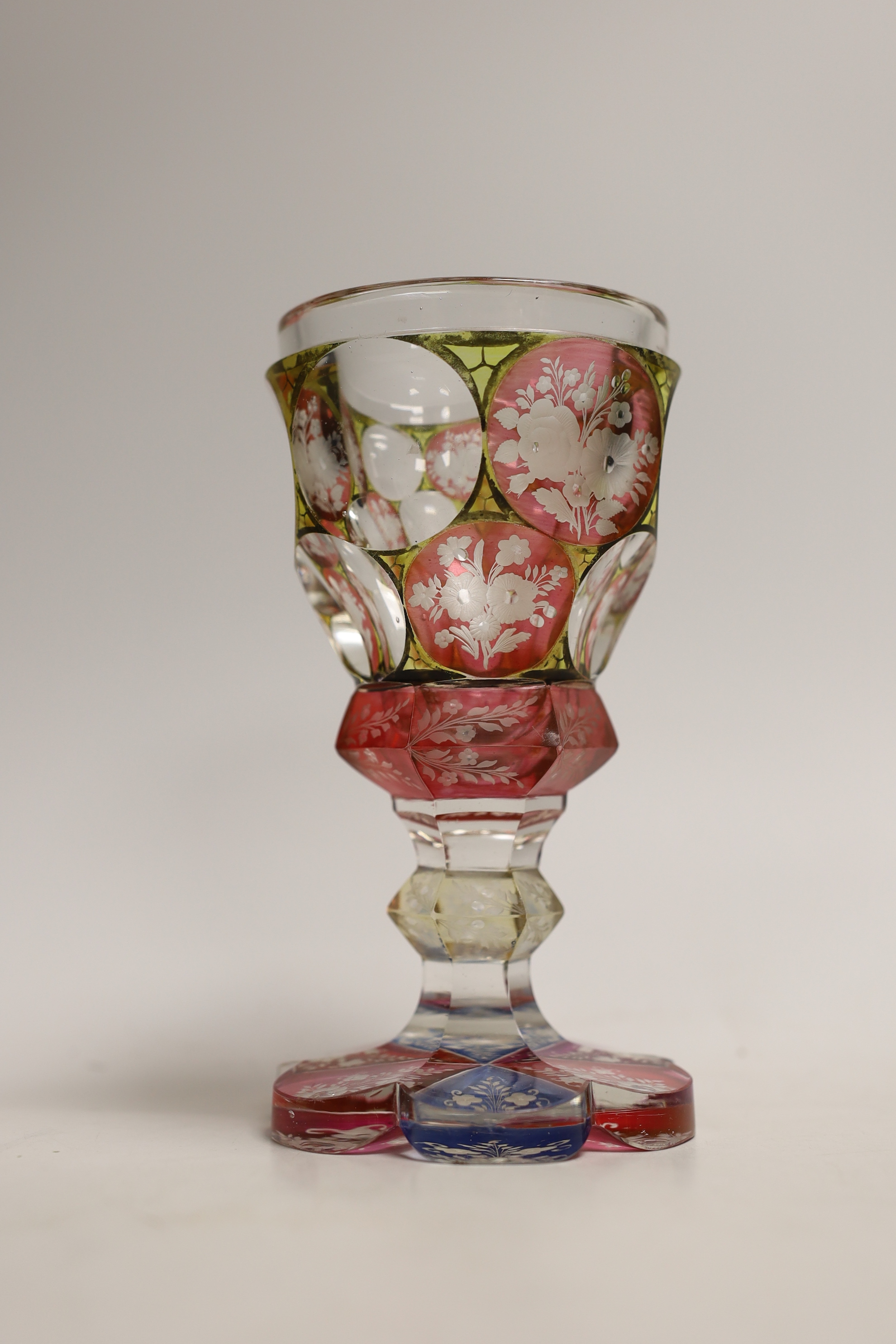 A Bohemian faceted, multicoloured flashed glass goblet, 16cm high